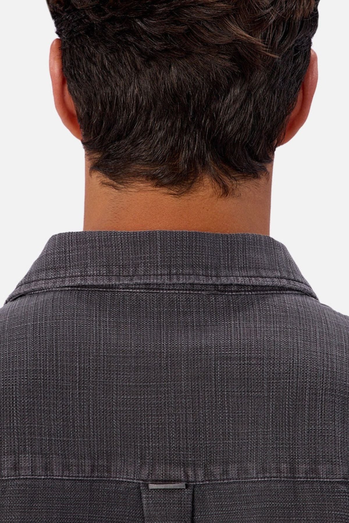 The image shows the back of a person with short brown hair, wearing the Industrie Lisbon Long Sleeve Shirt in textured dark gray 100% cotton with a classic collar, set against a light background.