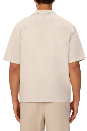 A person faces away, wearing the Industrie The Marbella Short Sleeve Shirt in a relaxed fit with matching beige shorts. The lightweight, textured shirt features a straight hem, set against a plain white background.