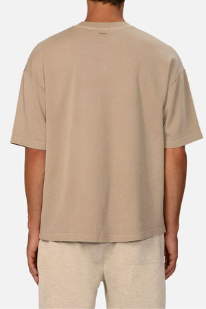 A person is seen from the back against a plain light background, wearing the Industrie The Marlon Tee in beige and light beige shorts—an effortlessly stylish choice for casual wear.