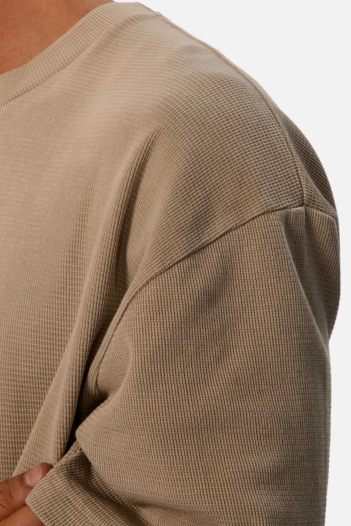 Close-up of a person in Industrie The Marlon Tee, a light brown, relaxed fit top with waffle knit texture. Ribbed details accent the shoulder and upper arm, with neckline and sleeve partially visible—ideal for casual wear.