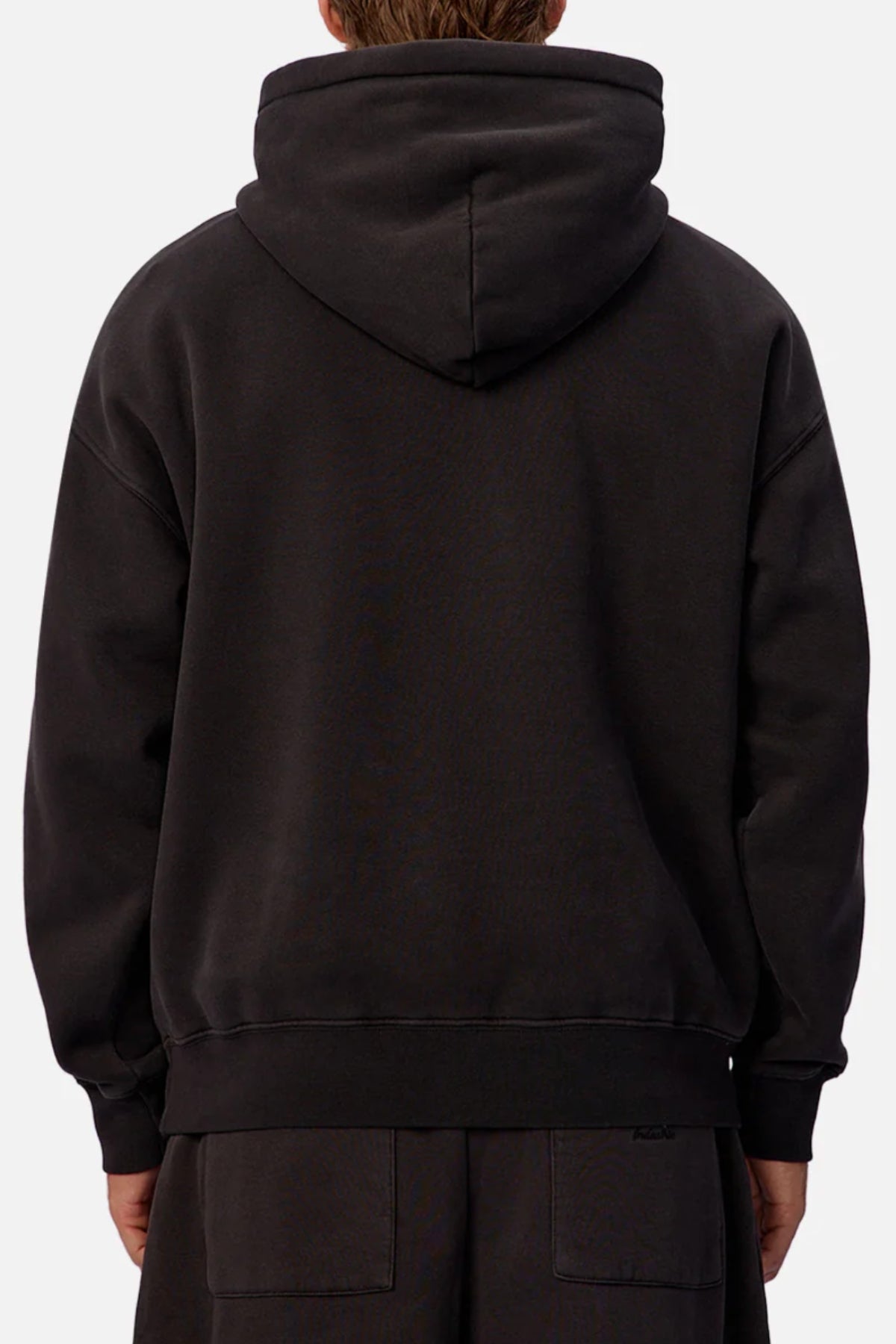 A person wearing the Industrie The New Del Sur Fleece Hoodie and matching black pants is shown from the back, hood up, with hands relaxed by their sides.