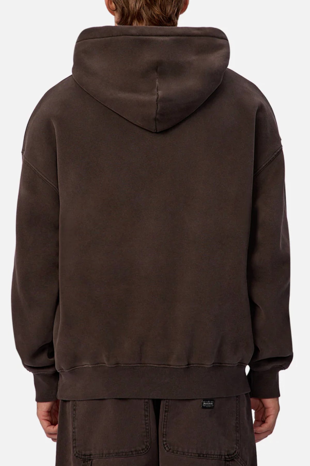A person is seen from behind wearing an Industrie The New Del Sur Fleece Hoodie in dark brown with the hood down and matching pants. The loose-fit hoodie has ribbed cuffs and hem, set against a plain, light background.