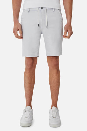 Wearing the Industrie The New Drifter Cuba Short in light gray with a drawstring, paired with a white shirt and sneakers, this look highlights comfortable fashion and a modern slim fit against a plain white background.
