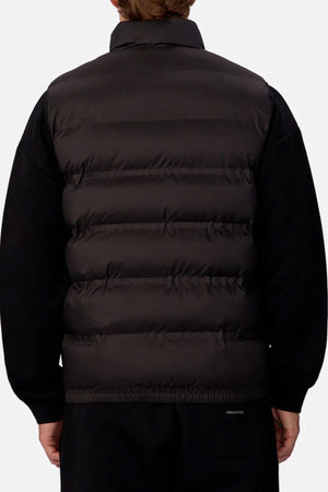 A person is shown from the back against a plain light background, wearing the Industrie The New Kyoto Puffer Vest with heat-sealed seams over a black long-sleeve shirt.