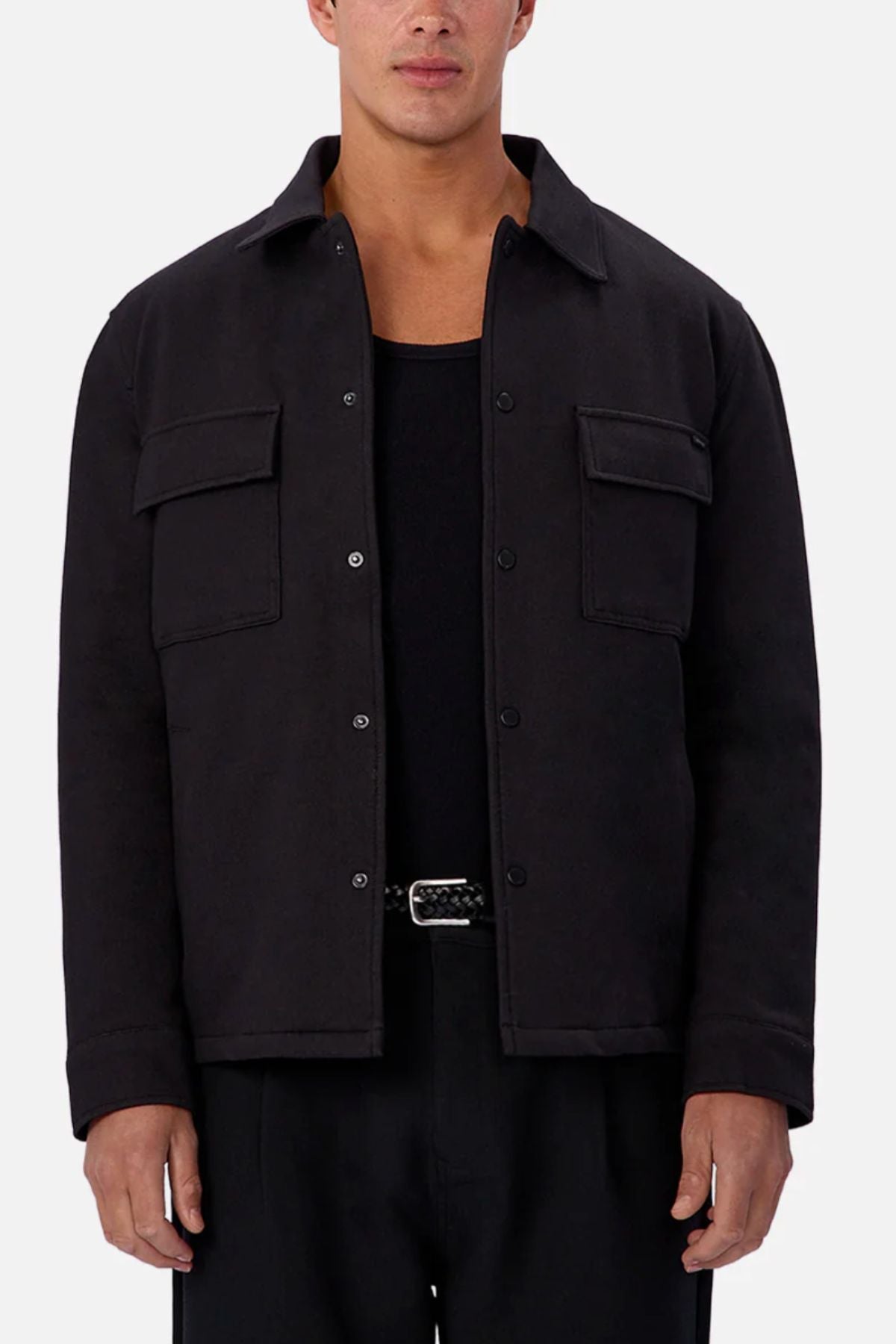 A person wearing the Industrie The New Westport Jacket over a black shirt and black pants stands against a plain light background. The jacket features two front chest pockets.