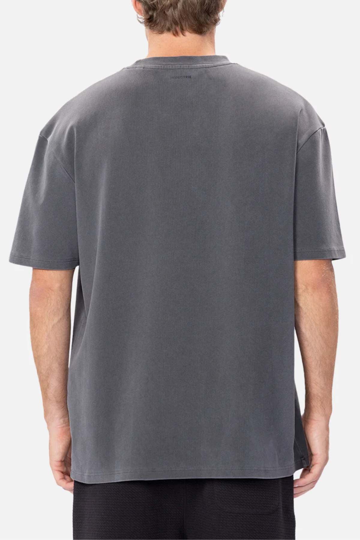 A person with short brown hair wears an oversized charcoal gray Industrie The Newport Tee, made of 100% cotton with a soft, slightly worn texture. They stand against a plain white background.