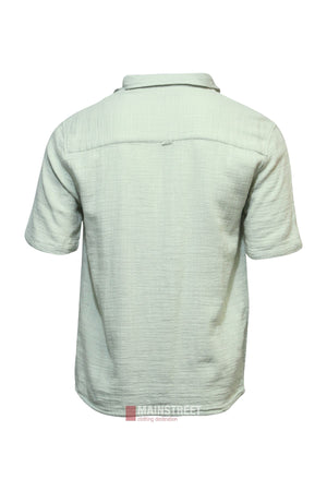 Back view of the Industrie The Seguro Short Sleeve Shirt in light green, showcasing textured fabric and a collar. This loose fit shirt has no visible patterns or logos and is set against a white background.