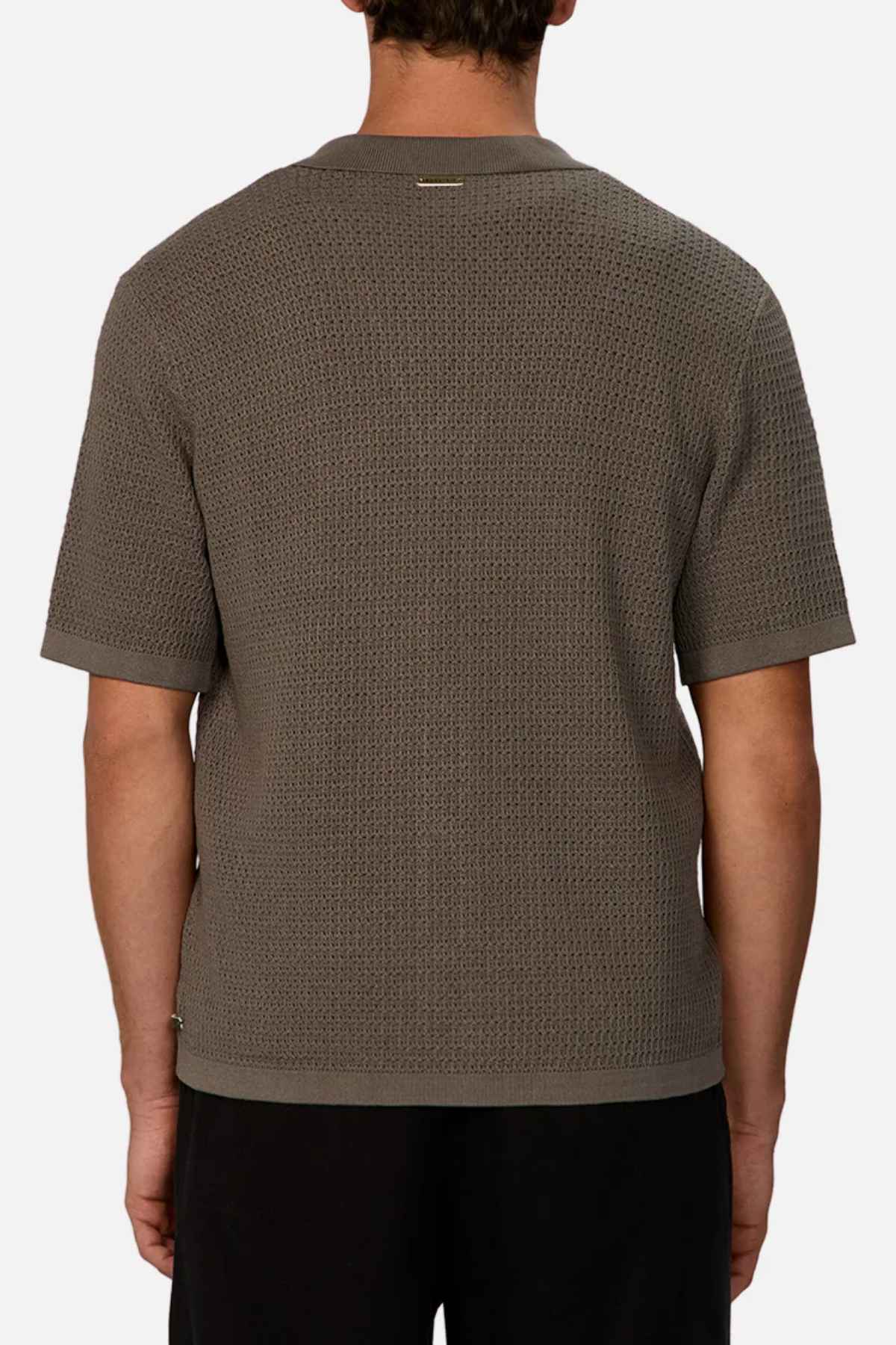 A person is seen from the back wearing an Industrie The Sevona Short Sleeve Shirt in textured gray, showcasing its relaxed fit alongside black pants against a simple white backdrop. The shirt exhibits a subtle pattern with small horizontal detailing close to the collar, making it ideal for any summer wardrobe.