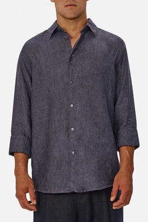 A man wears the Industrie The St Martins Shirt, a regular fit, long-sleeve, button-up charcoal gray shirt with sleeves slightly rolled up, standing against a plain white background.