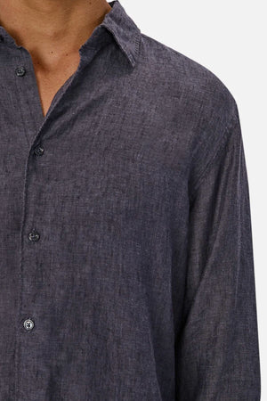 A close-up shows a person wearing the Industrie The St Martins Shirt in dark gray linen, regular fit with buttons and a collar. Only the chest, neck, and part of the left arm are visible against a plain light background.