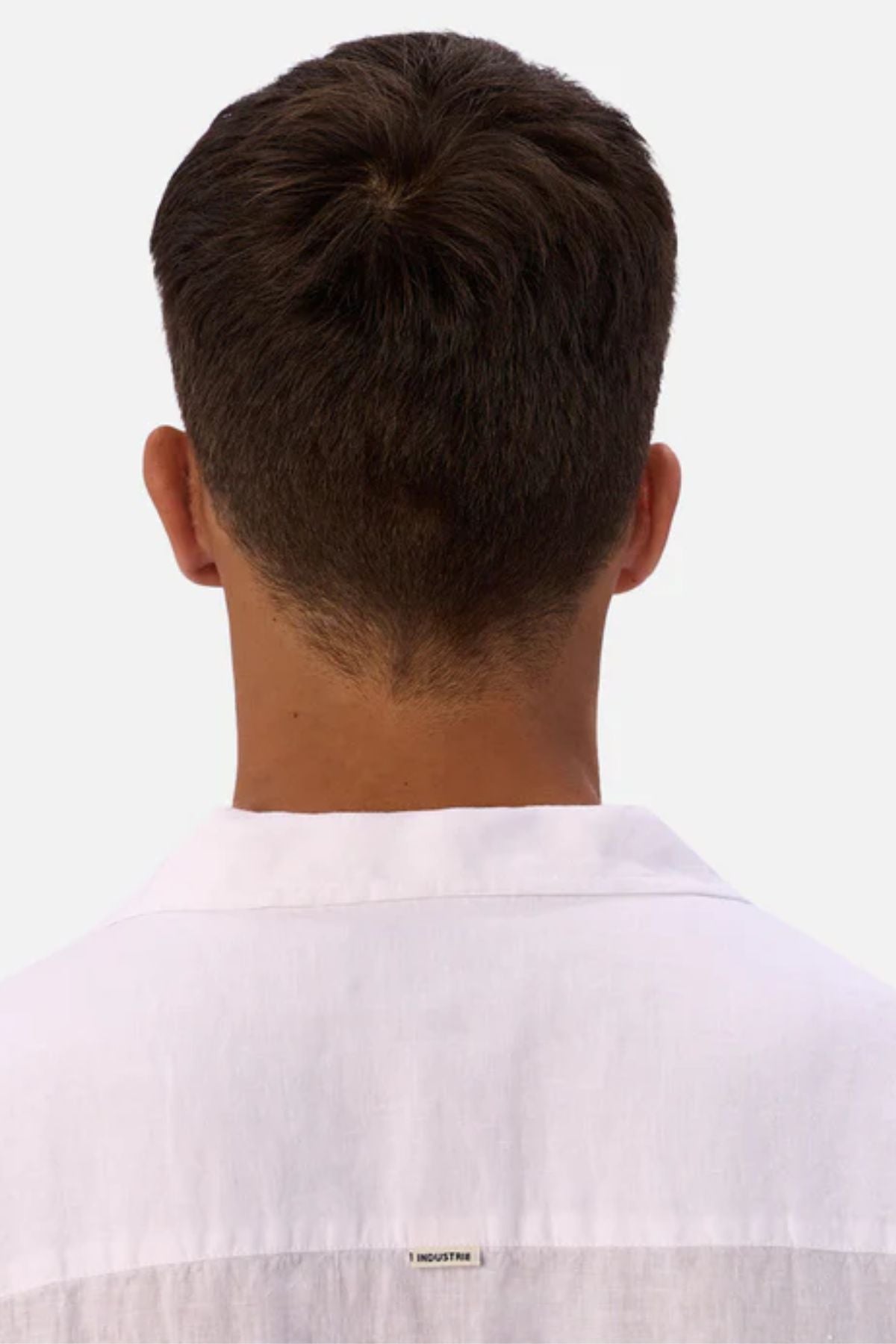 A person with short brown hair is shown from behind, wearing the Industrie The St Martins Short Sleeve Shirt in white against a plain, light-colored background.