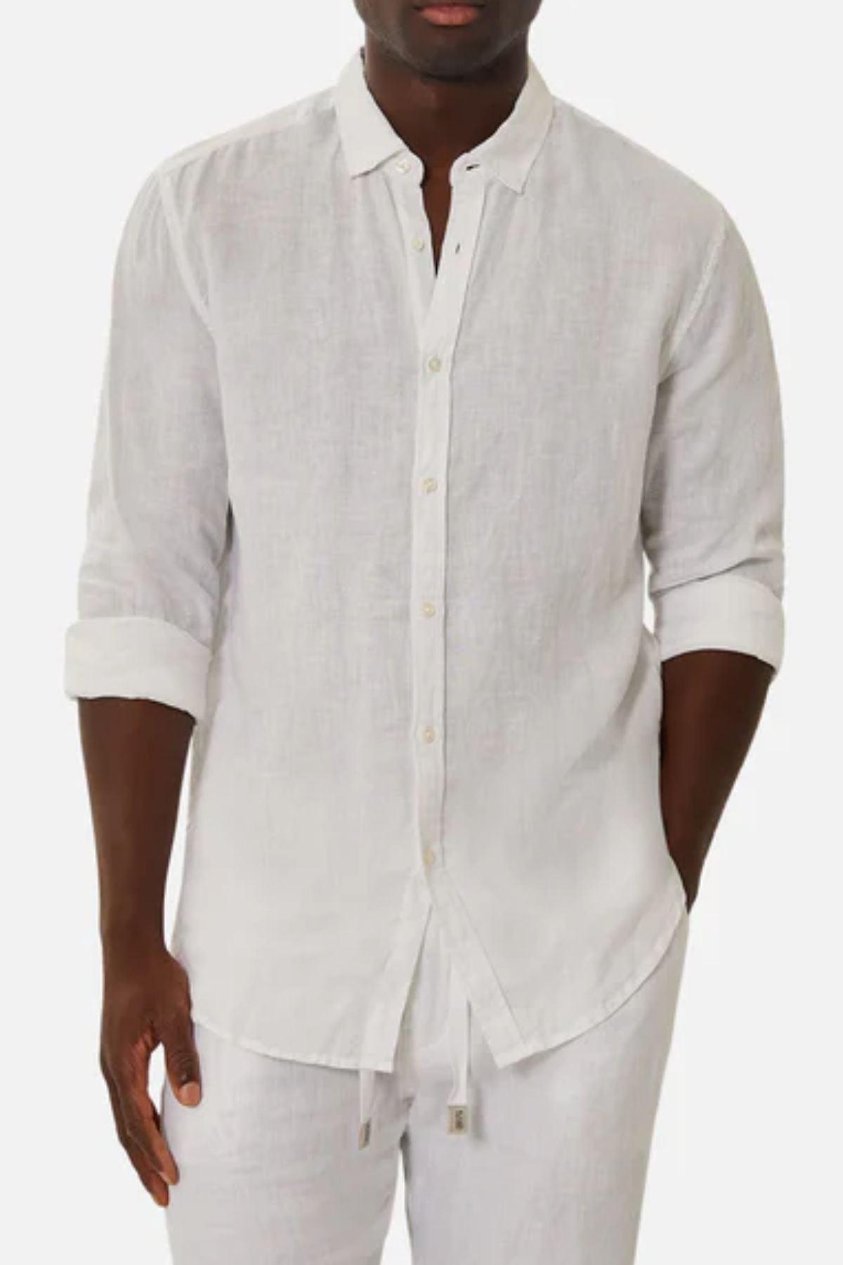 Someone wears the Industrie The Tennyson Linen Blend Shirt, a lightweight white linen blend with rolled-up sleeves, paired with matching white pants against a plain background.