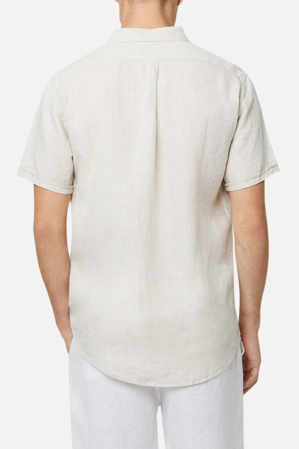 A man is shown from the back in an Industrie The Tennyson Linen Short Sleeve Shirt and white pants against a plain white background, emphasizing the shirt’s breathable linen fabric.