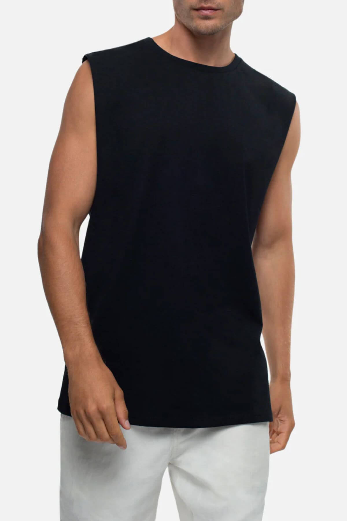 Sporting a relaxed fit, the individual dons an Industrie The Triple G Sleeveless Tee in black, made from 100% cotton, paired with white pants. Posed against a plain white background, only one hand is partly visible.
