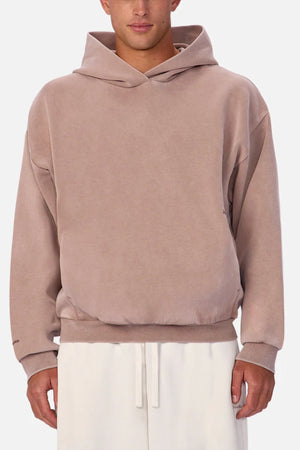 Wearing the Industrie The Washed Tech Hood in light brown with a front pocket and white pants, this look is ideal for fans of contemporary casual style against a simple background.