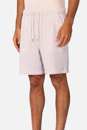 A person wears Industrie The Frescati Short—light-colored, knee-length men's summer shorts with subtle vertical stripes, side pockets, and a relaxed fit. Only the lower torso and legs are shown.