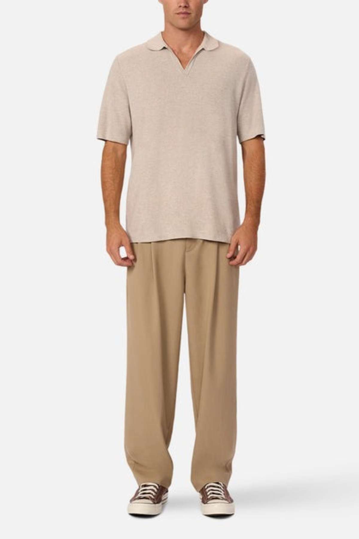 Industrie - The hampshire polo shirt - in colour beige marle - a warm light coloured polo shirt. A man modelling the shirt with brown trousers. 