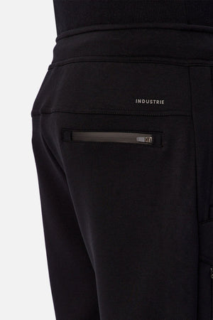 Close-up of the back pocket on Industrie The Tech Armoured Track Pant in black, featuring a zippered pocket and "INDUSTRIE" branding above, highlighting its tactical design.