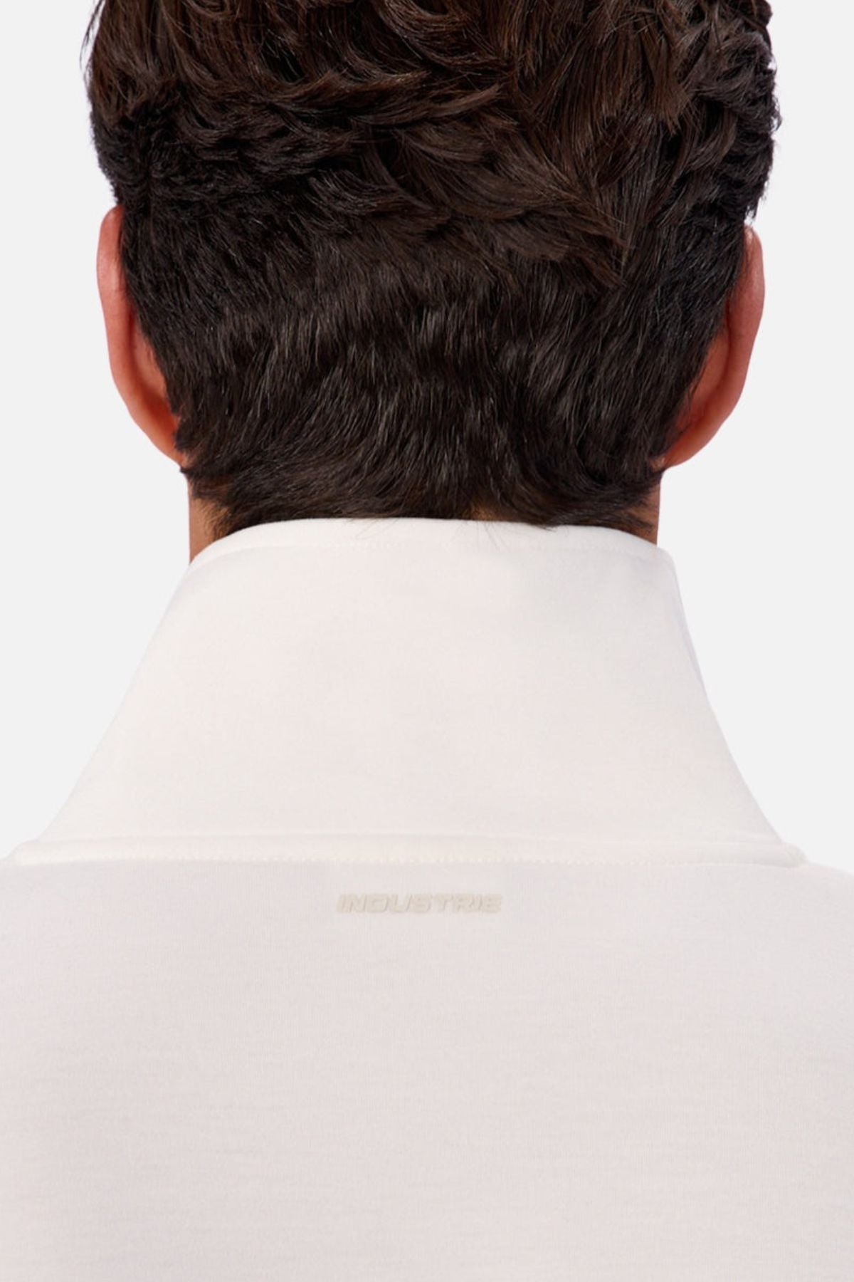A person with short dark hair is shown from behind, wearing the Industrie The Tech Southend Track Top in white, which features subtle text on the back of the collar for a casual look.