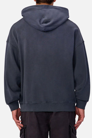 Someone wearing the Industrie The Sandblast Hoodie, made from 100% cotton, and dark pants is seen from behind against a plain light background, highlighting a relaxed style.