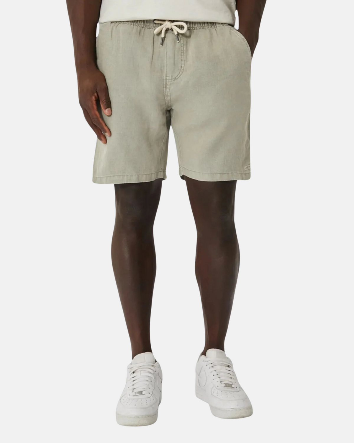 A person is wearing light gray Industrie The Marina Linen Short, paired with a white shirt and white sneakers, standing against a plain background. Only the lower half of the body is visible, showcasing the relaxed-fit style of the Industrie The Marina Linen Short.