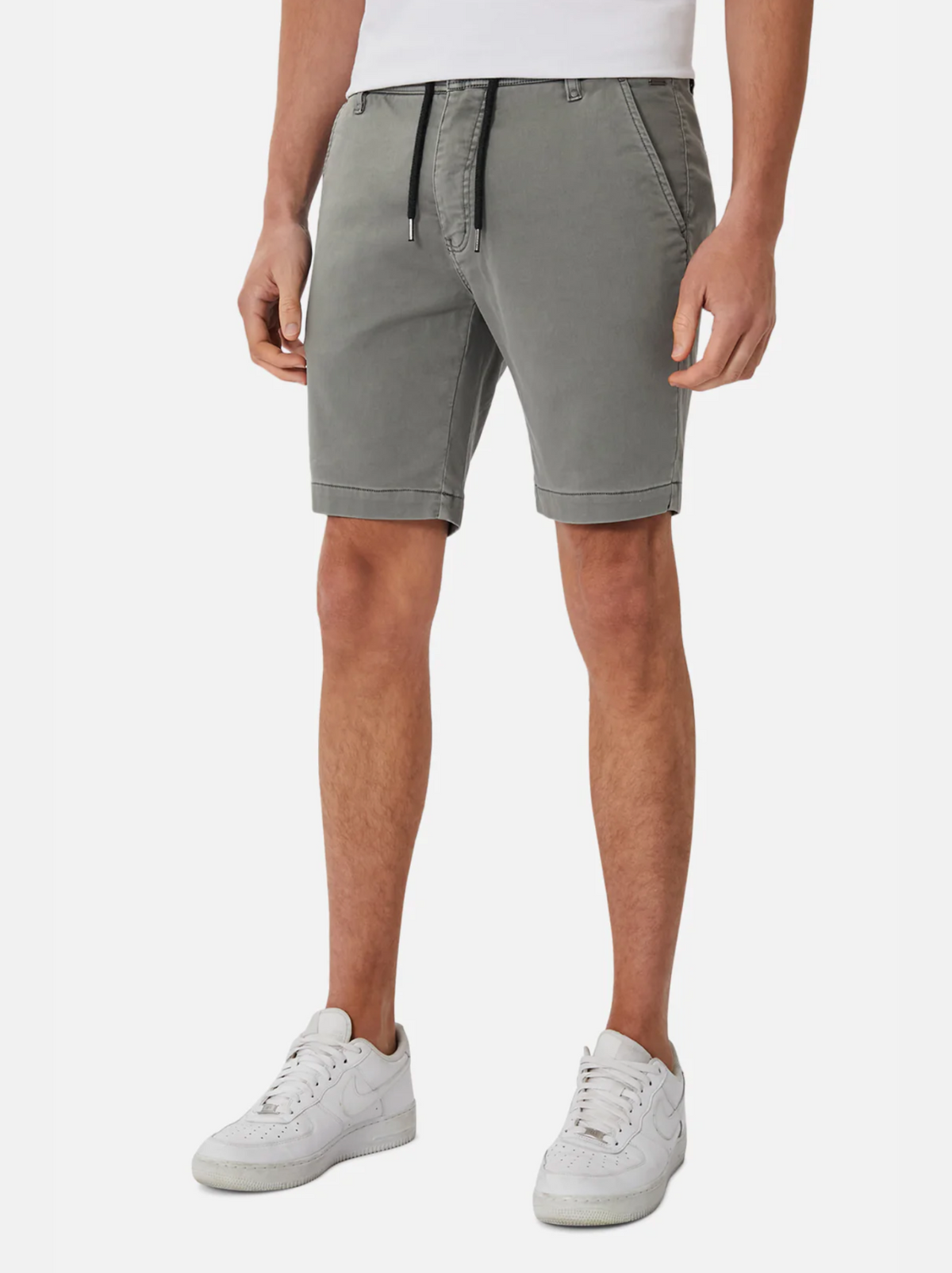 Someone stands against a plain white background, shown from shoulders to feet, wearing the Industrie The New Drifter Cuba Short in gray paired with a tucked-in white t-shirt and white sneakers.