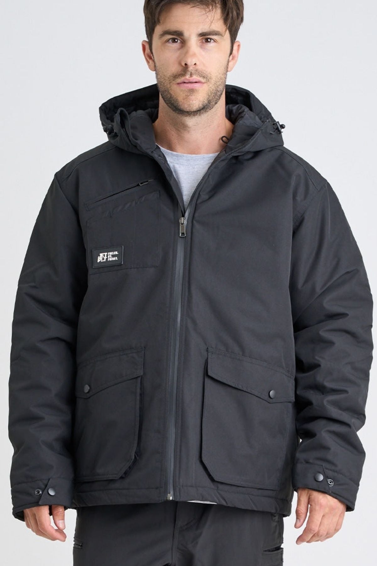 A man faces the camera against a plain light background, wearing a Jetpilot Onsite Pro Jacket made from polyester cotton twill with front pockets and snap buttons.
