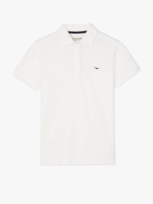 The RM Williams Margaret Polo is a white short-sleeve shirt in soft pique cotton with a ribbed collar, button placket, and dark embroidered logo on the left chest, shown against a white background.