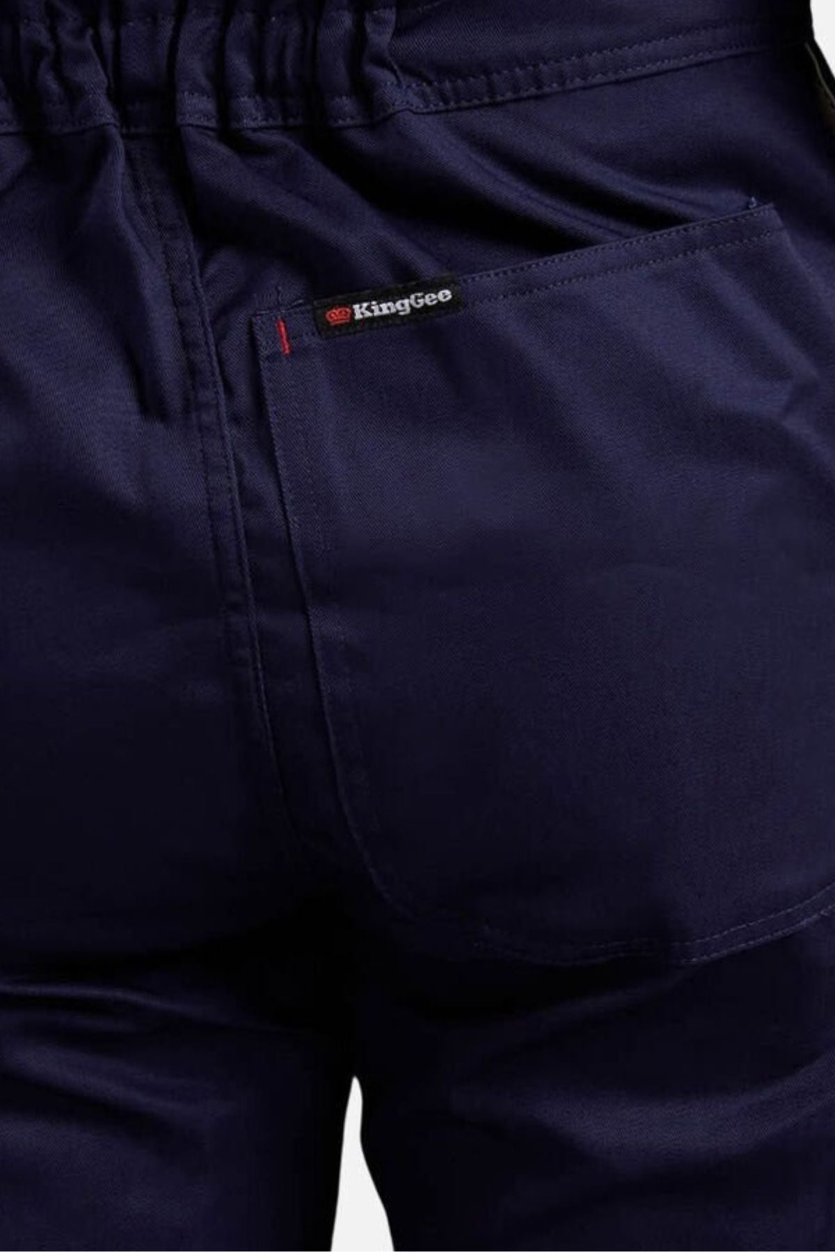 Close-up of the back of dark blue King Gee Combination Drill Overall, highlighting durable craftsmanship with detailed back pocket, waistband, and King Gee label above the pocket.