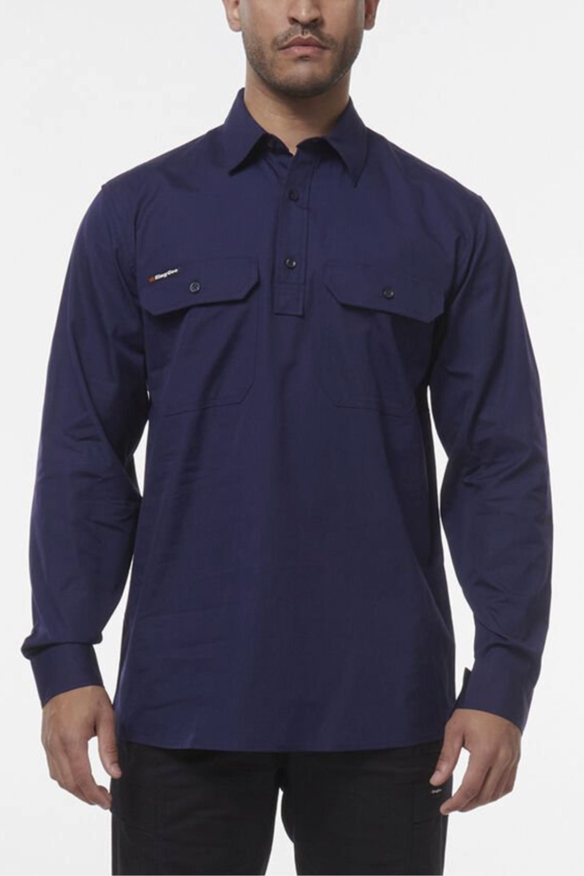 A man wearing a King Gee Workcool Vented Closed Front Shirt in long-sleeved navy blue with two chest pockets, standing against a plain white background.