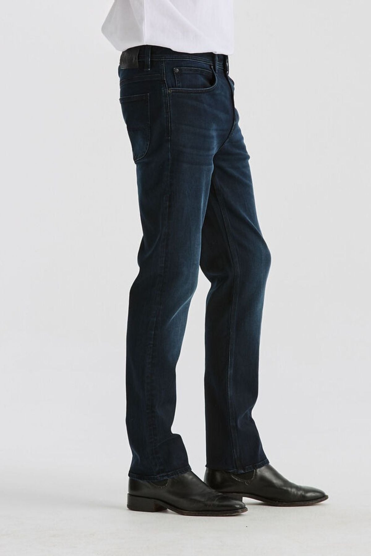 A person wears Lee Originals L100 Slim Jean and black dress shoes, standing against a plain white background. Only the lower half is visible, highlighting the comfortable fit of the jeans.