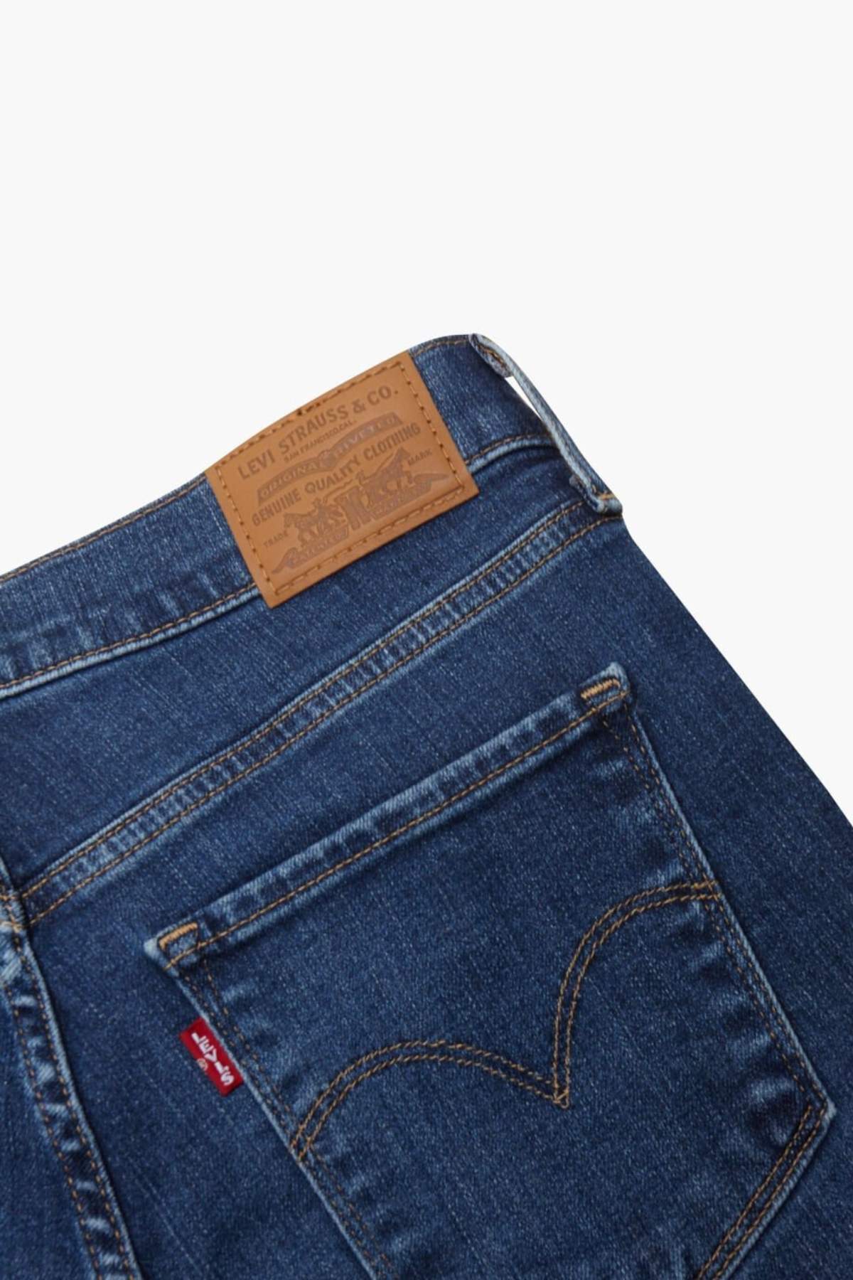 Close-up of the back pocket and waistband of Levis 312 Shaping Slim Jean in blue stretch denim, featuring a brown leather brand patch and the classic red Levi’s tag on the pocket—signature details of this iconic style.