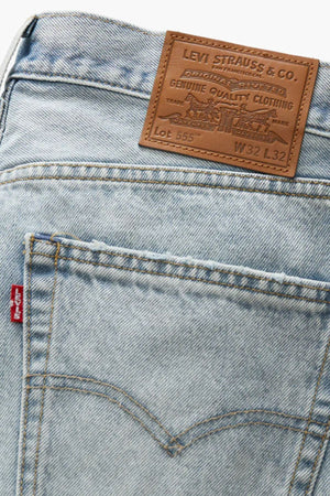 Close-up of the back pocket and waistband of the Levis 555 Relaxed Straight Jean in light blue, made from non-stretch denim, with the signature leather patch and red tag for a vintage-inspired touch.