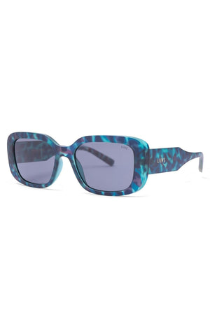 Liive Fringe Blue Meanie Sunglasses feature 90s-inspired rectangular frames in a blue havana marbled finish, shown at a slight angle. "LIVEE" is printed in small letters on the lens and temple.