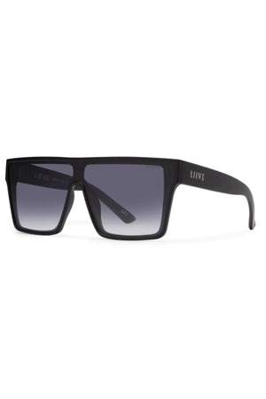 Liive Wasteland Sunglasses feature a bold black rectangular shape with thick frames, dark gradient lenses, and “LIIVE” branding on the left temple. The oversized flat-top design creates a modern statement look.