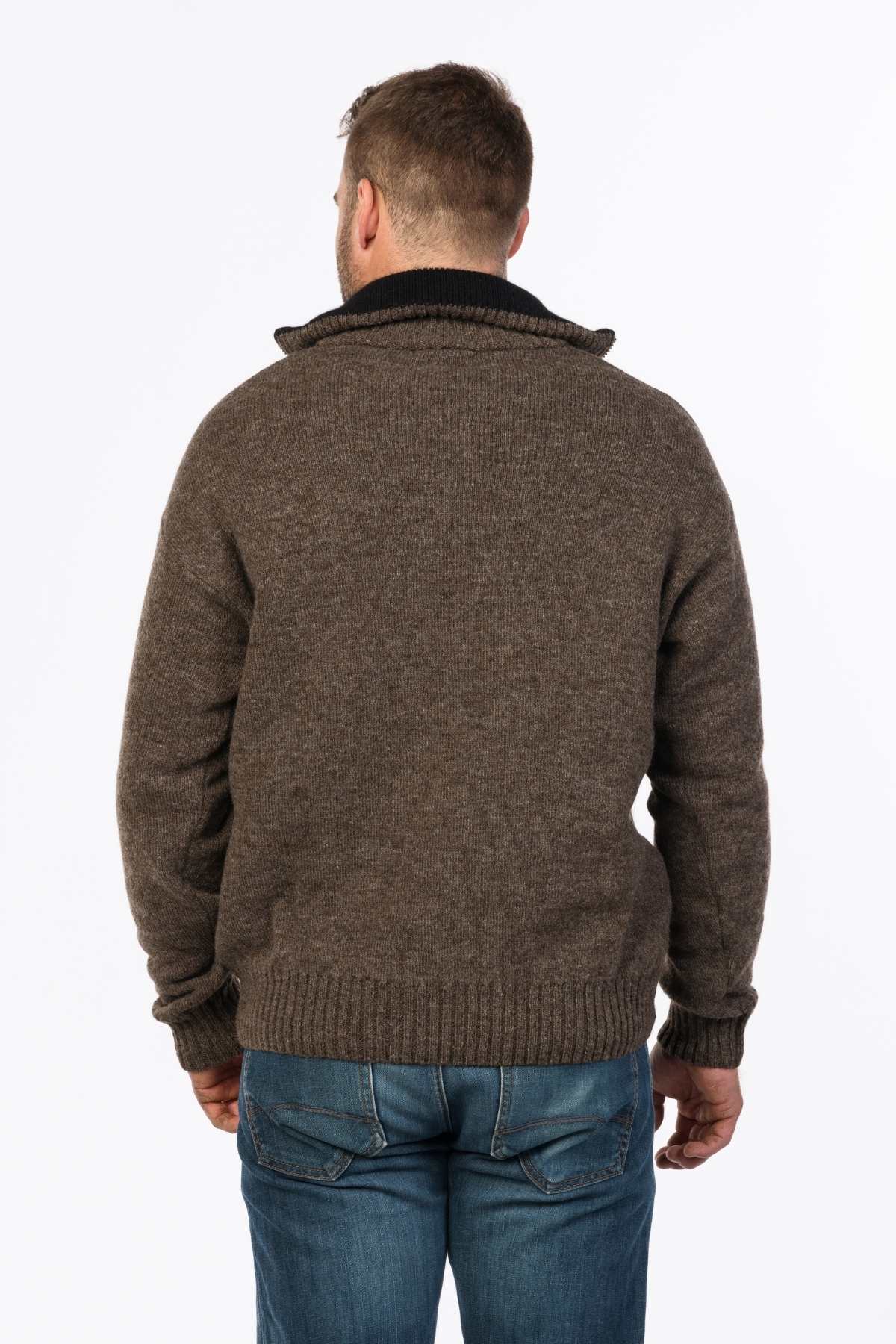 A person in a MKM Tasman Dual Layer Possum & Merino Knit sweater, featuring a brown knit design, pairs it with blue jeans as they stand facing away against a plain white background.