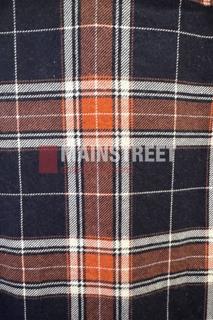 A close-up of the Milton Open Front Flannelette Shirt highlights its plaid fabric in black, orange, and white lines. The words "MAIN STREET" are subtly visible over the premium cotton material.