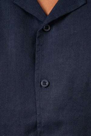 Close-up of the Mr Simple Cuban Short Sleeve Shirt in dark navy blue linen, featuring two visible buttons and part of the collar, showcasing its textured fabric and relaxed fit.