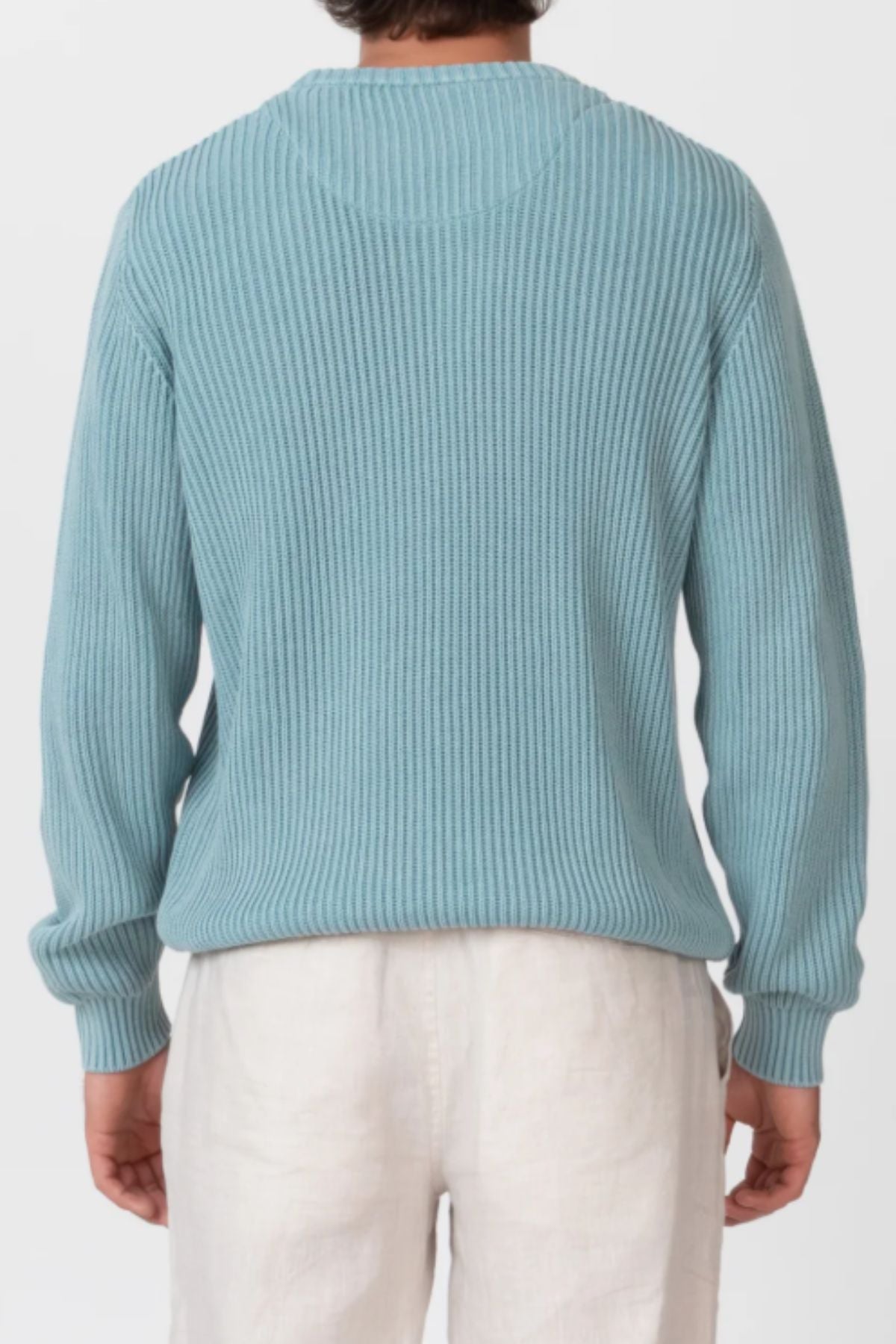 A person is shown from the back against a plain white background, wearing the Mr Simple Fisher Knit sweater in light blue with a relaxed fit, paired with white pants.