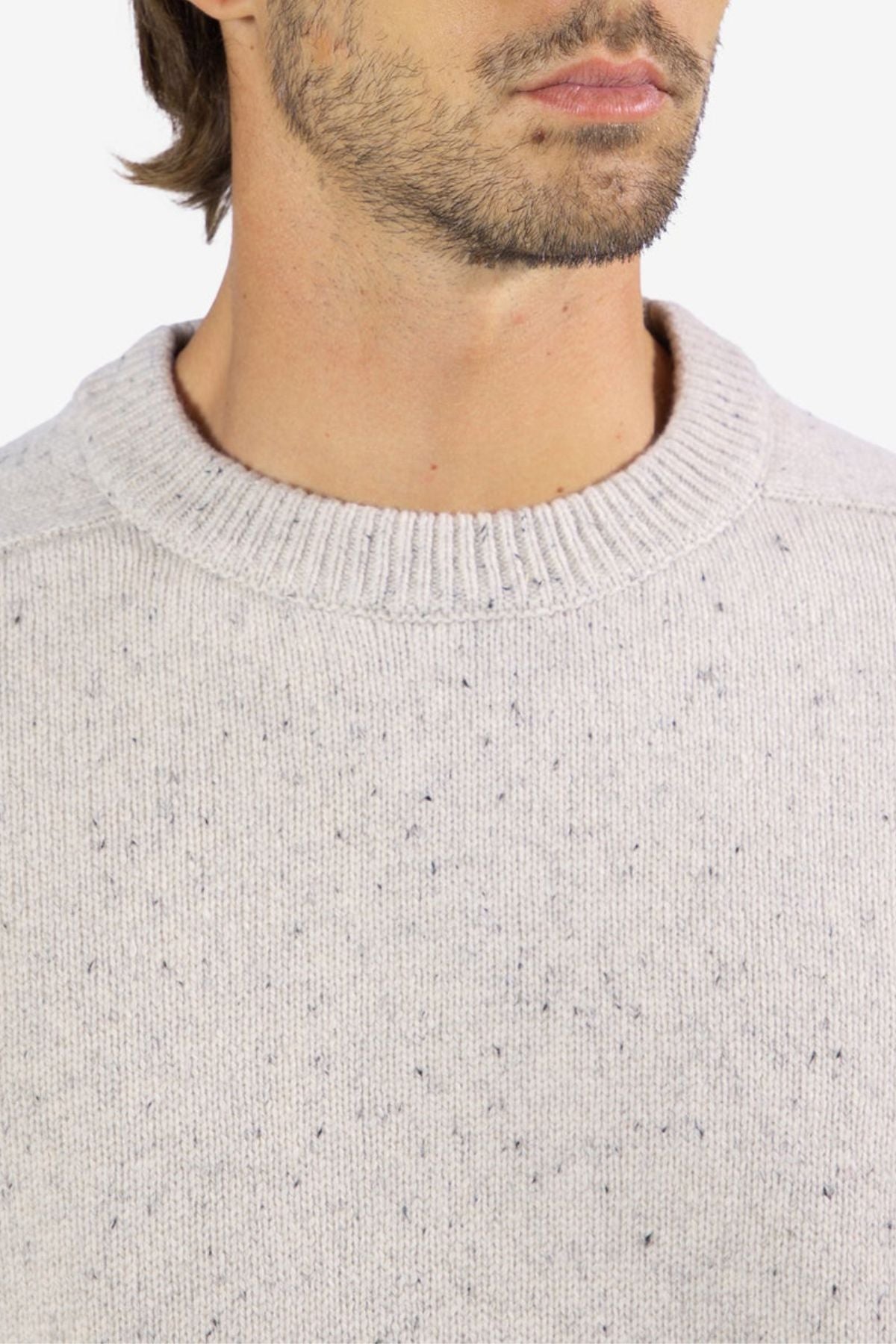 A close-up shows a man wearing the Mr Simple Fred Knit, a light gray 100% wool jumper with speckled texture and ribbed crew neck; only his lower face, neck, and upper chest are visible—ideal for winter style.