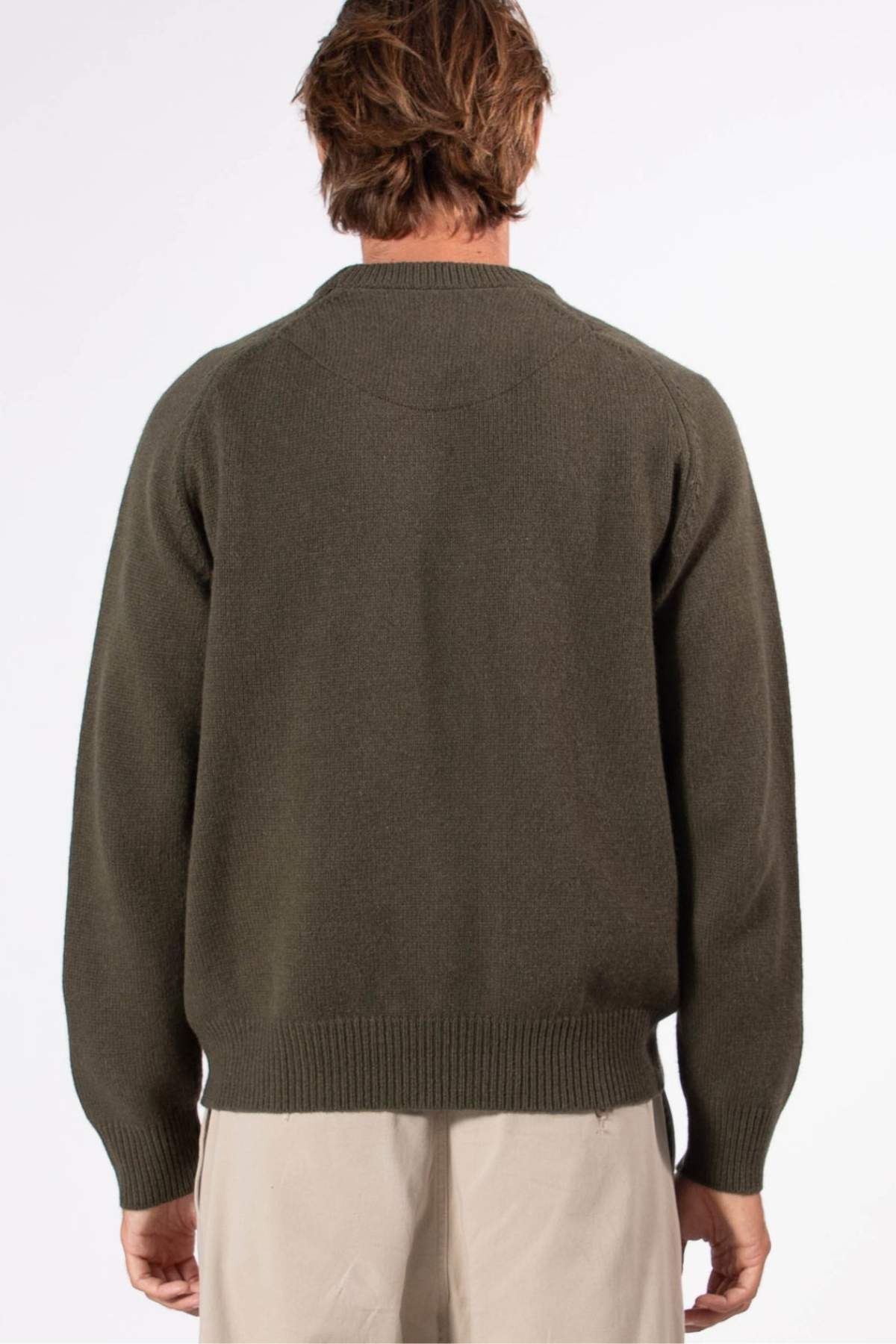 Seen from behind, a person with short brown hair wears the Mr Simple Fred Knit in olive green and light beige pants against a plain white background—an ideal winter wardrobe addition.