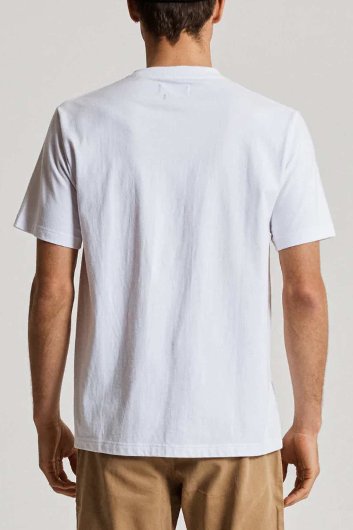 A person is seen from behind wearing a Mr Simple Heavy Weight Tee, crafted from 100% organic cotton, and beige pants. They're set against a neutral backdrop, highlighting the supreme comfort and fit of the T-shirt.