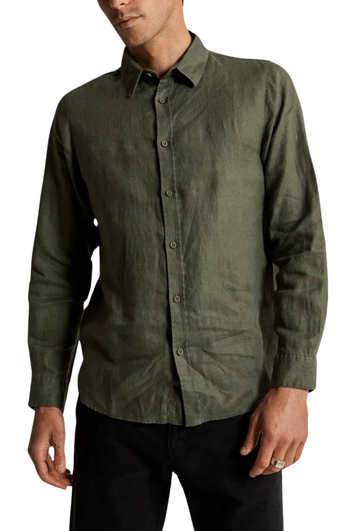 A person is wearing a Mr Simple Linen Long Sleeve Shirt, dark olive-green, with long sleeves and a classic collar, paired with black pants. The shirt is loose-fit and made of textured fabric. They stand with one hand in a pocket.