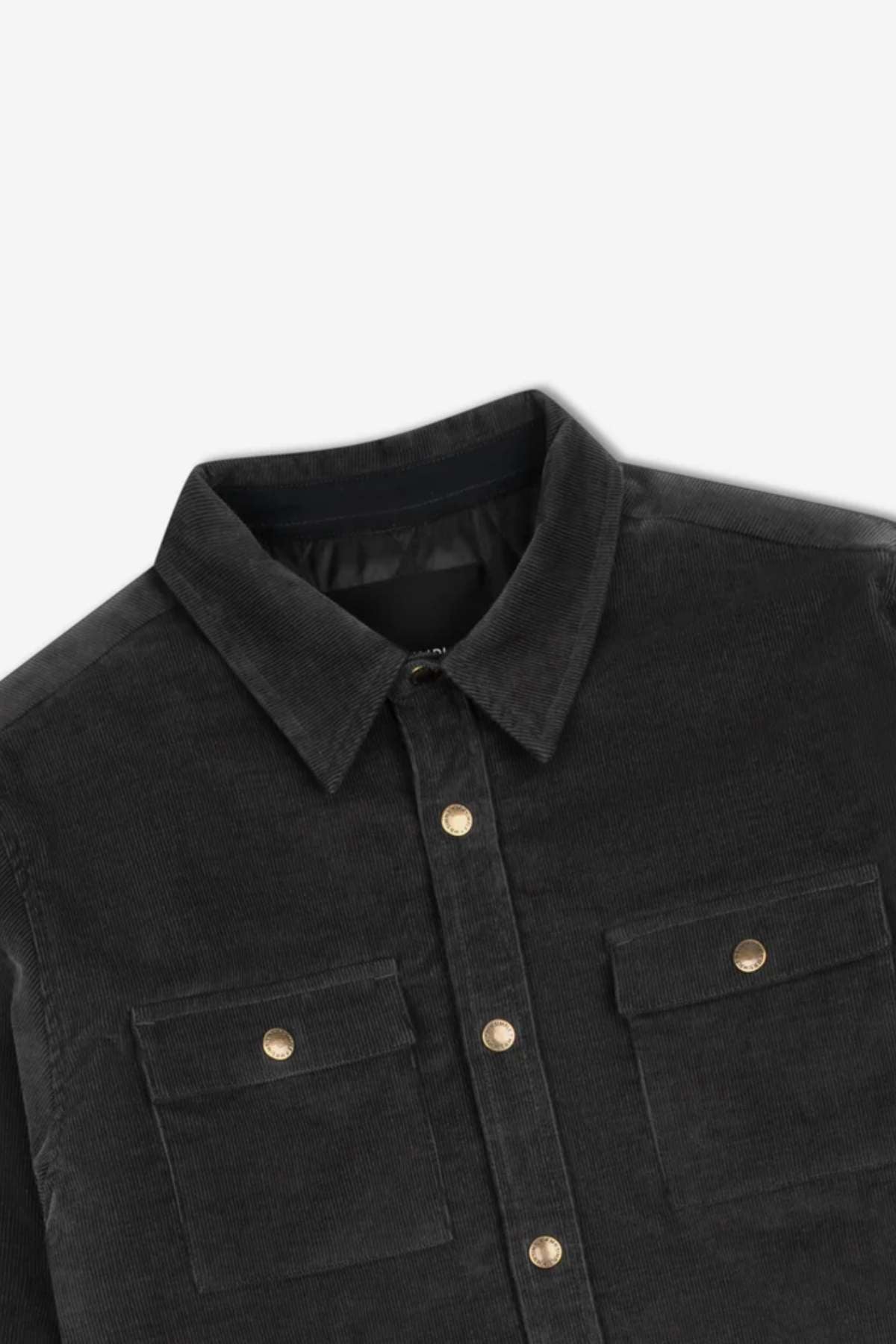 A close-up image of the Mr Simple Quilted Cord Jacket, a black cotton corduroy button-up shirt featuring a collar and two chest pockets with button flaps. The relaxed fit jacket is laid flat, showcasing the front detailing and gold button accents.
