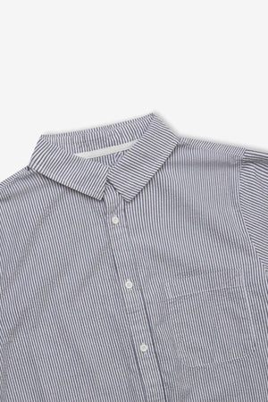 A close-up of the Mr Simple Seersucker Short Sleeve Shirt, featuring thin blue and white vertical stripes, collar, white buttons, and chest pocket—laid flat on a white background for a fresh summer look.