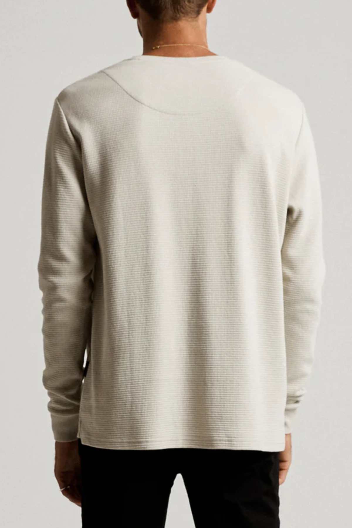 Seen from the back, the person wears a Mr Simple Smith Waffle shirt in organic cotton with a subtle texture. This classic-fit long sleeve reaches the hips and pairs perfectly with dark pants for an effortlessly stylish look.