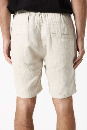 A person is seen from the back wearing Mr Simple Tanner 3.0 Linen Shorts in light beige, featuring an elastic waistband and two back pockets, paired with a black shirt against a plain white background.