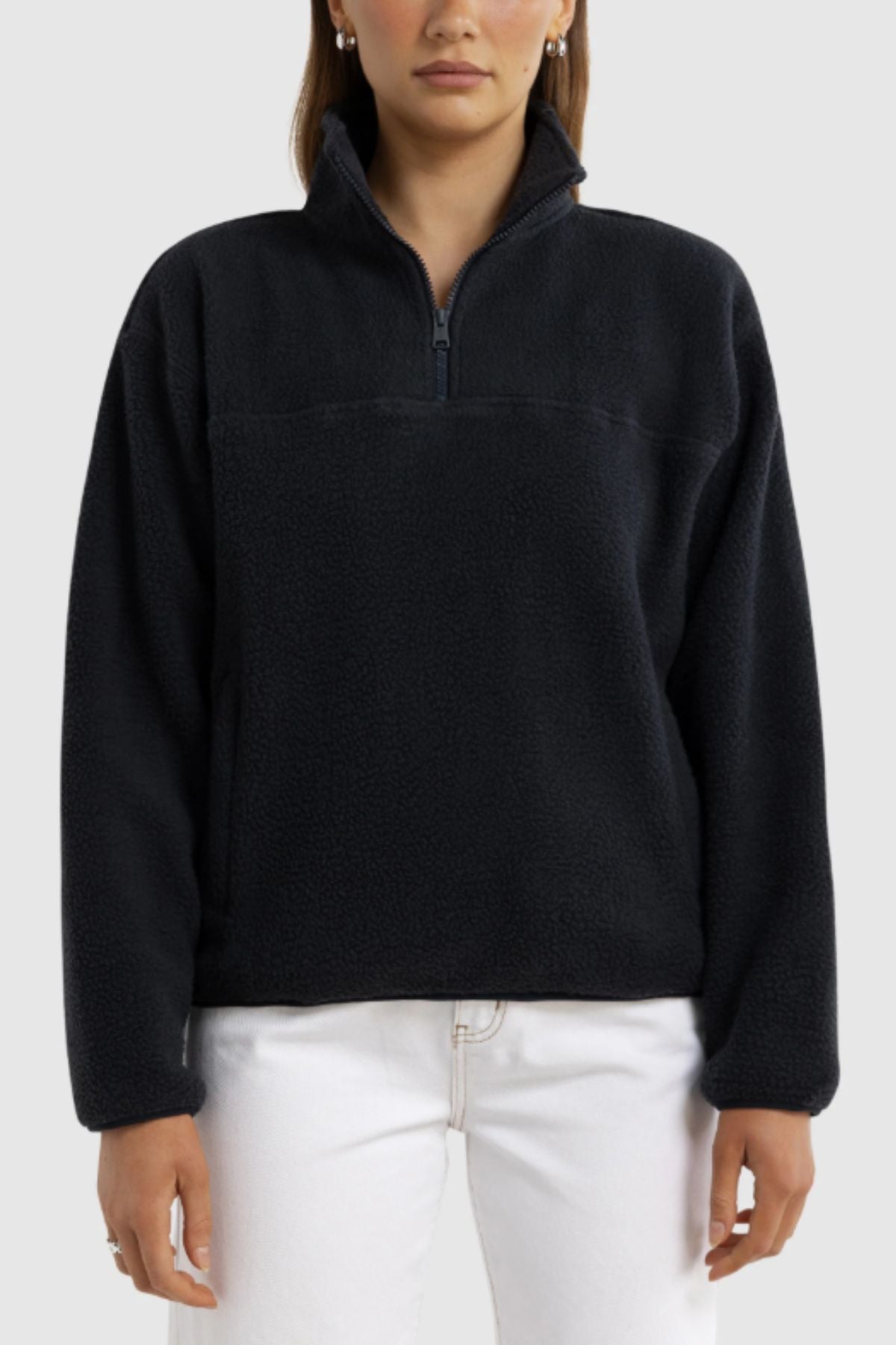 A person wearing the ORTC Sherpa Fleece Quarter Zip in black and white pants stands facing forward against a plain light gray background.