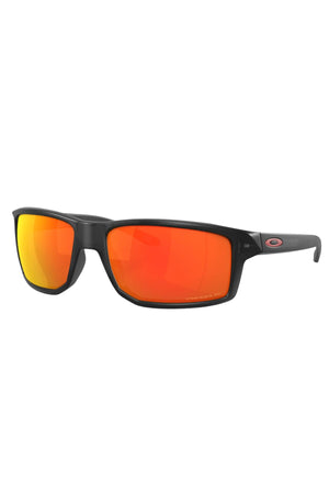 Oakley Gibston Polarized sunglasses feature black frames, rectangular mirrored orange-red Prizm lenses, and a subtle Oakley logo on the temple. Enjoy sharper vision with advanced Polarized Prizm lens technology.
