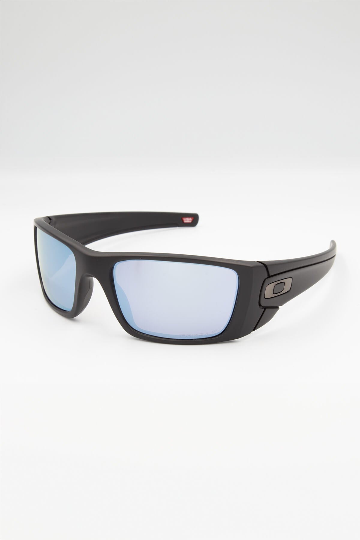 The Fuel Cell Polarized sunglasses boast a sleek black design with rectangular blue-tinted lenses and Oakley Fuel Cell™ frames. The smooth-finish frames feature a subtle logo on the temples, all set against a plain white background.